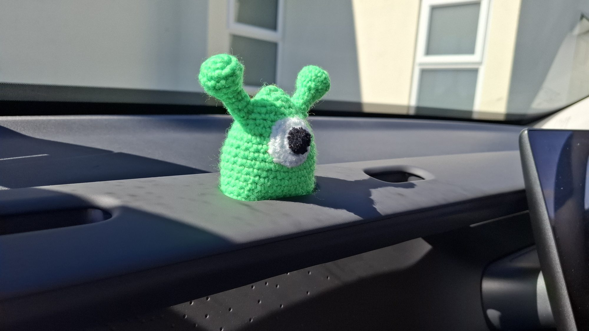 A little green one-eyed crocheted alien with antennae