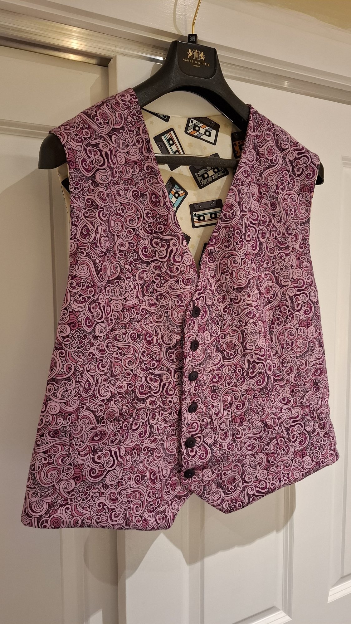 A tailored paisley waistcoat, hand-sewn, on a hanger